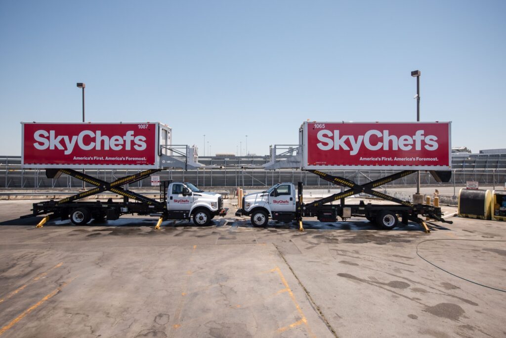 Two SkyChefs trucks, both manufactured by Mallaghan, parked at San Francisco International Airport.