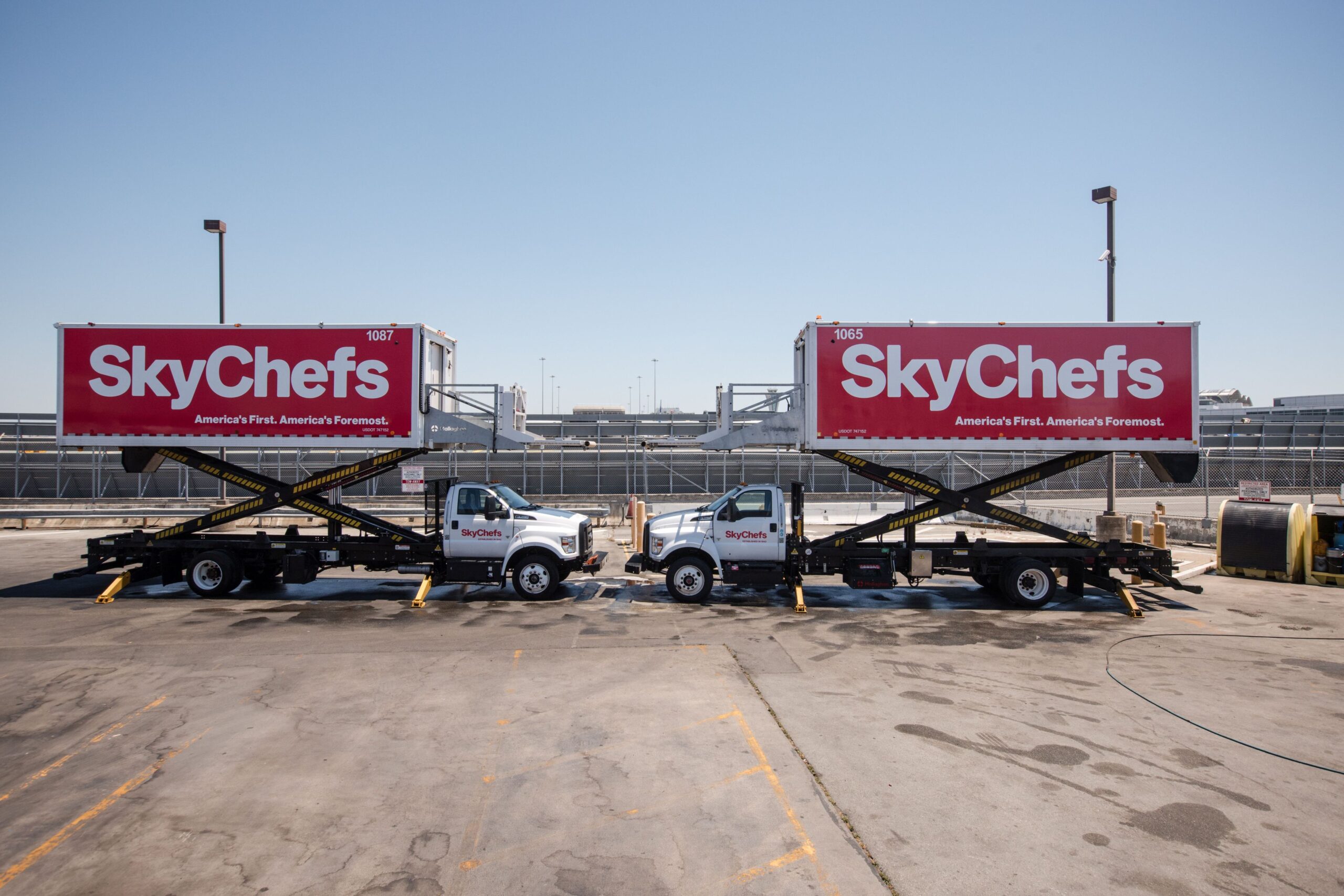 Two SkyChefs trucks, both manufactured by Mallaghan, parked at San Francisco International Airport.